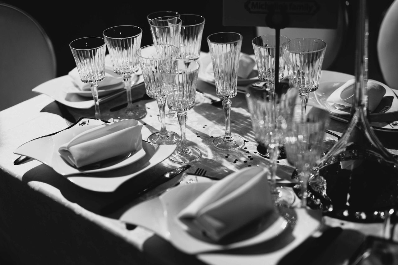 Stylish black and white dining setup with glassware and folded napkins at a wedding.